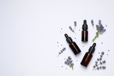 Photo of Composition with lavender flowers and natural essential oil on white background, top view