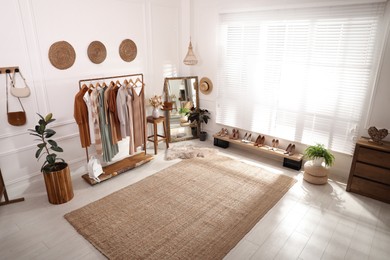 Photo of Dressing room interior with stylish clothes, shoes and accessories, above view