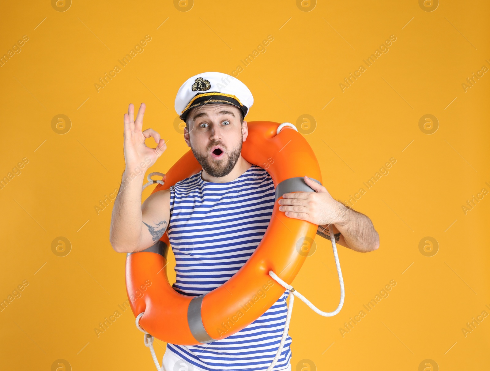 Photo of Emotional sailor with ring buoy on yellow background