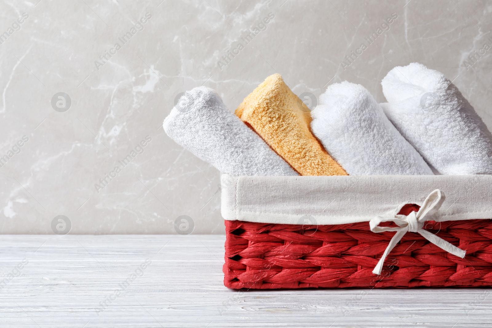 Photo of Basket with clean towels on table