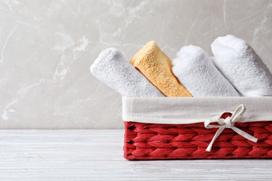 Photo of Basket with clean towels on table