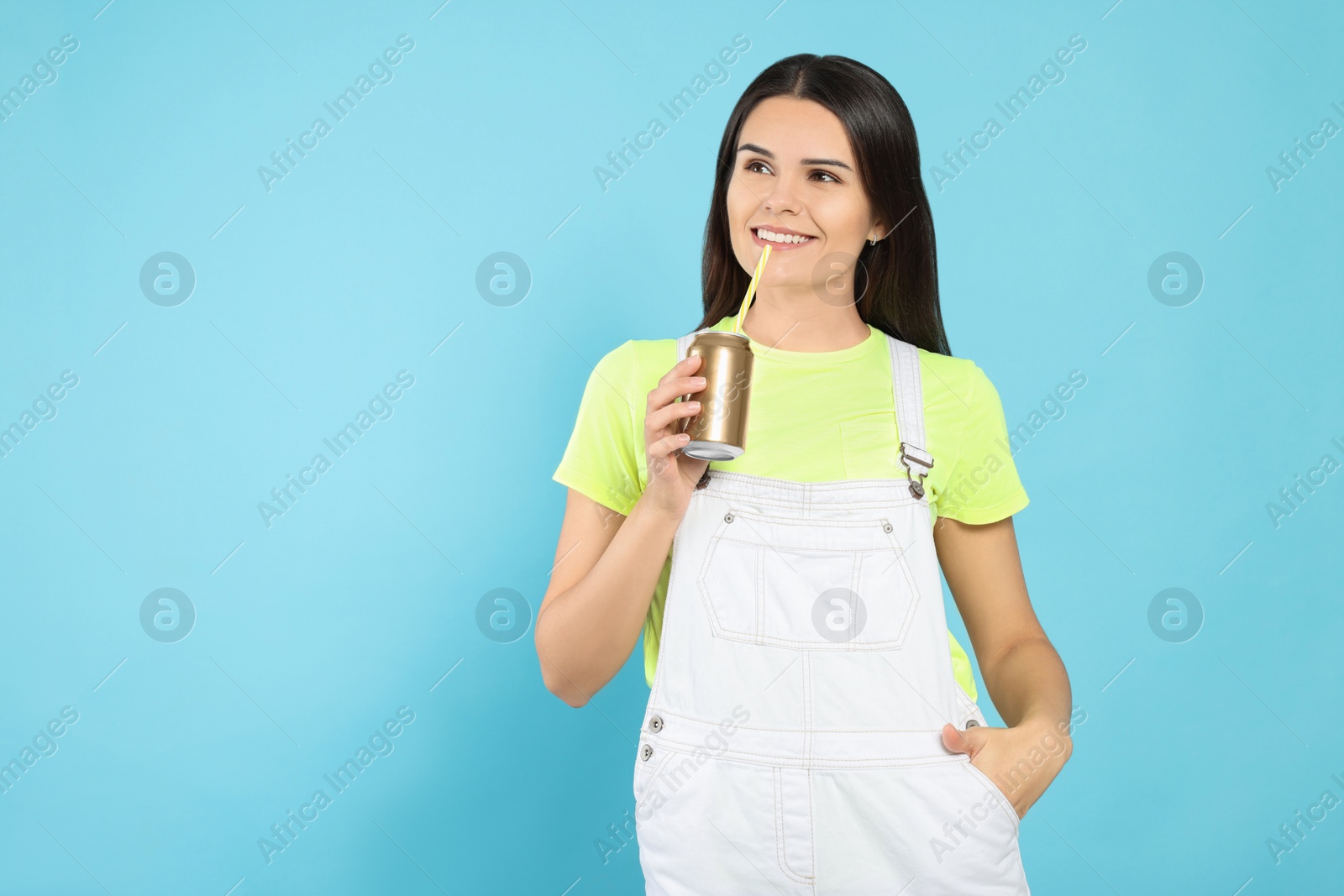 Photo of Beautiful happy woman drinking from beverage can on light blue background. Space for text