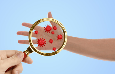 Image of Woman detecting bacteria with magnifying glass on blue background, closeup. Prevention disease