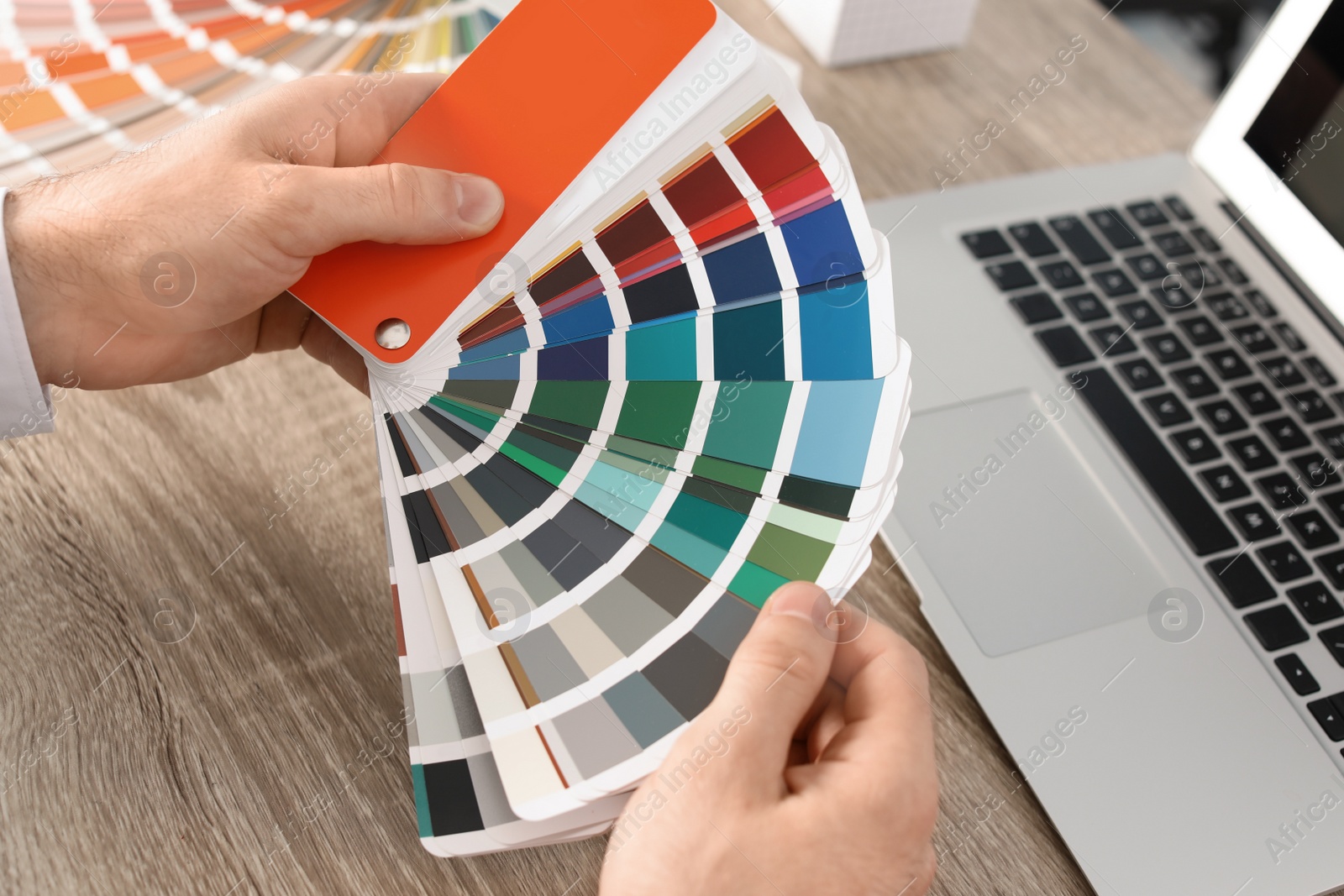 Photo of Male designer working with color palette at office table, closeup