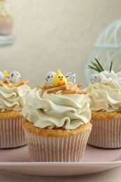 Photo of Tasty Easter cupcakes with vanilla cream on table