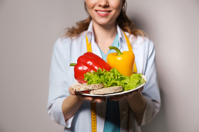 Photo of Nutritionist with healthy products on light grey background, closeup