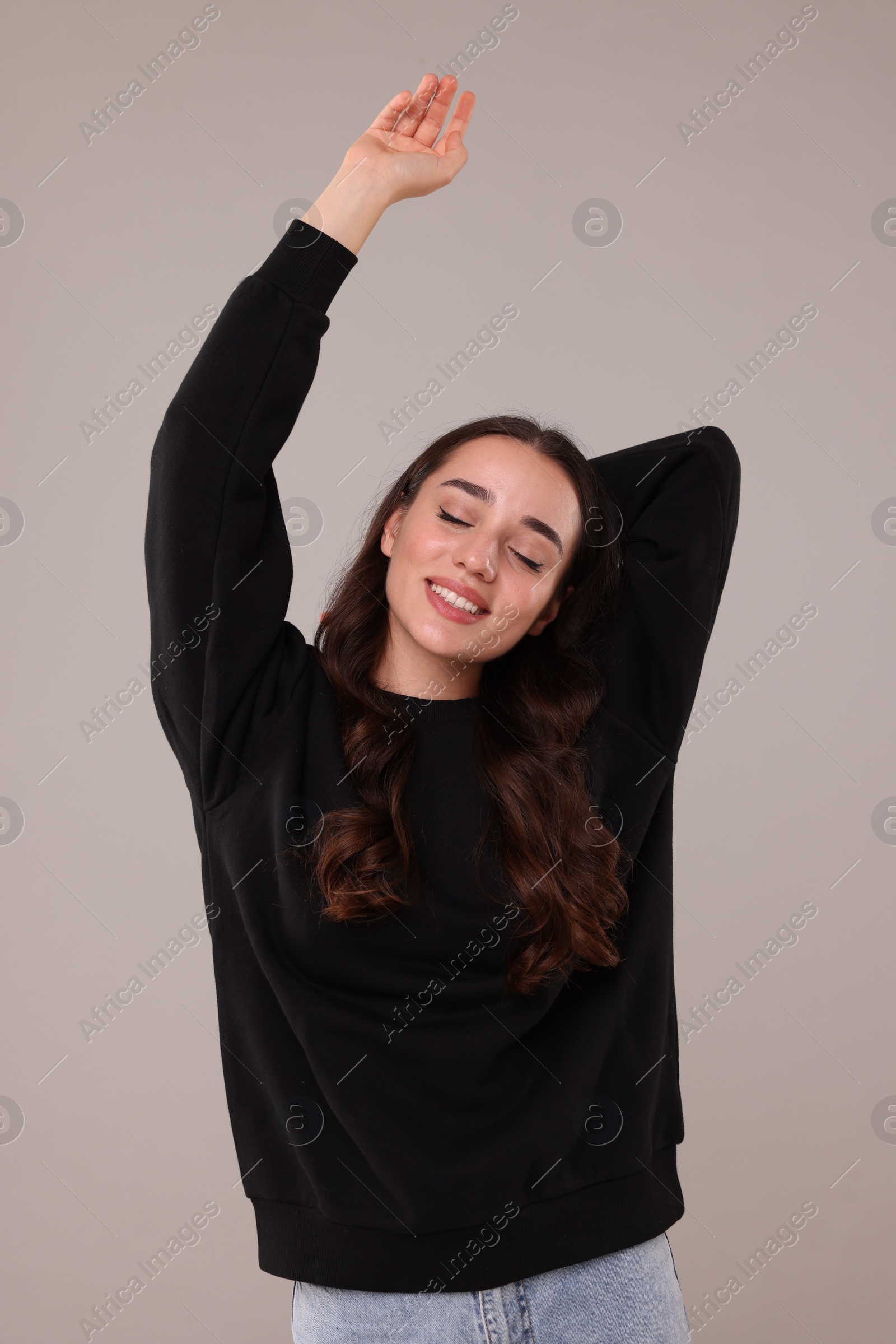 Photo of Beautiful young woman in stylish warm sweater on grey background