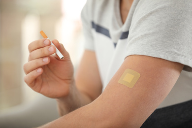 Photo of Man with nicotine patch and cigarette, closeup