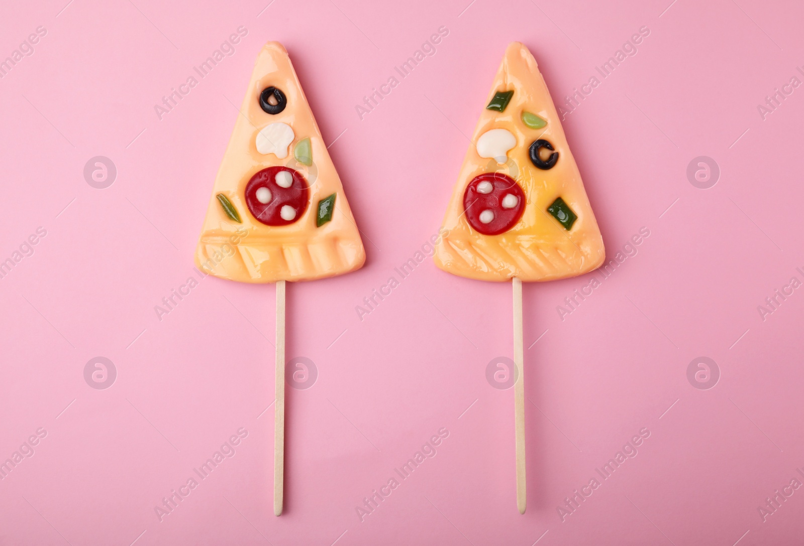 Photo of Pizza shaped lollipops on pink background, flat lay