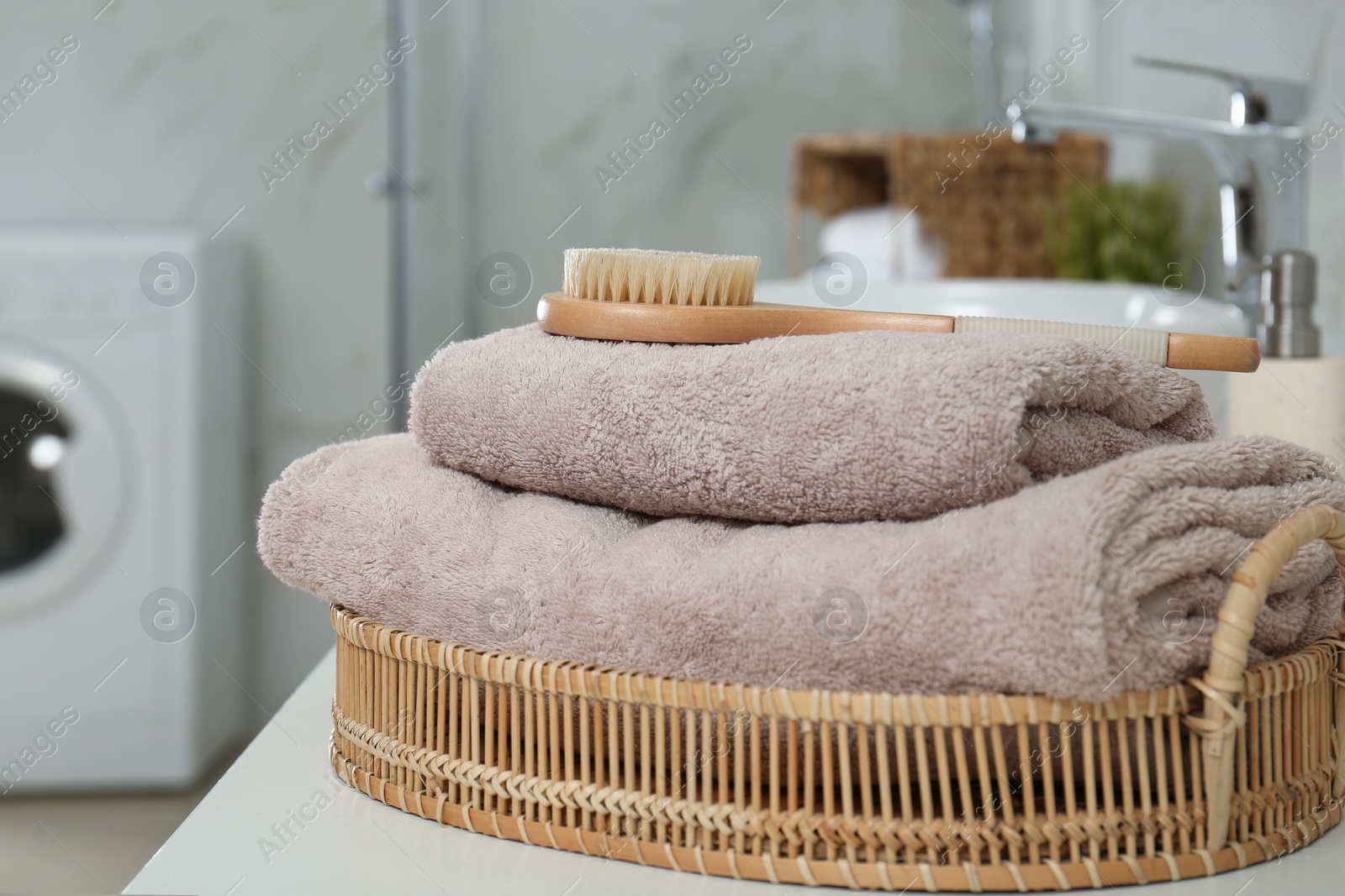 Photo of Clean towels and shower brush on countertop in bathroom