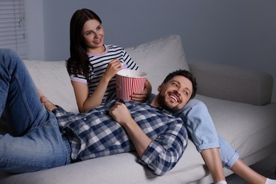 Photo of Happy couple watching TV at home in evening