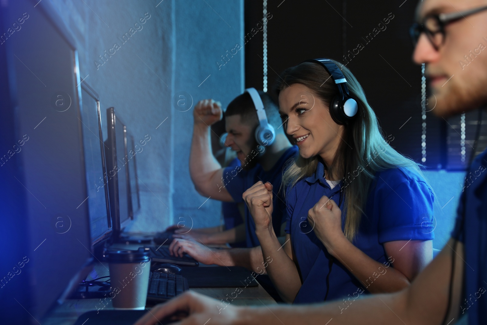 Photo of Group of people playing video games in internet cafe, color tone