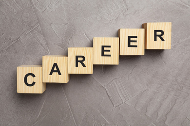 Photo of Wooden cubes with word CAREER on grey background, flat lay