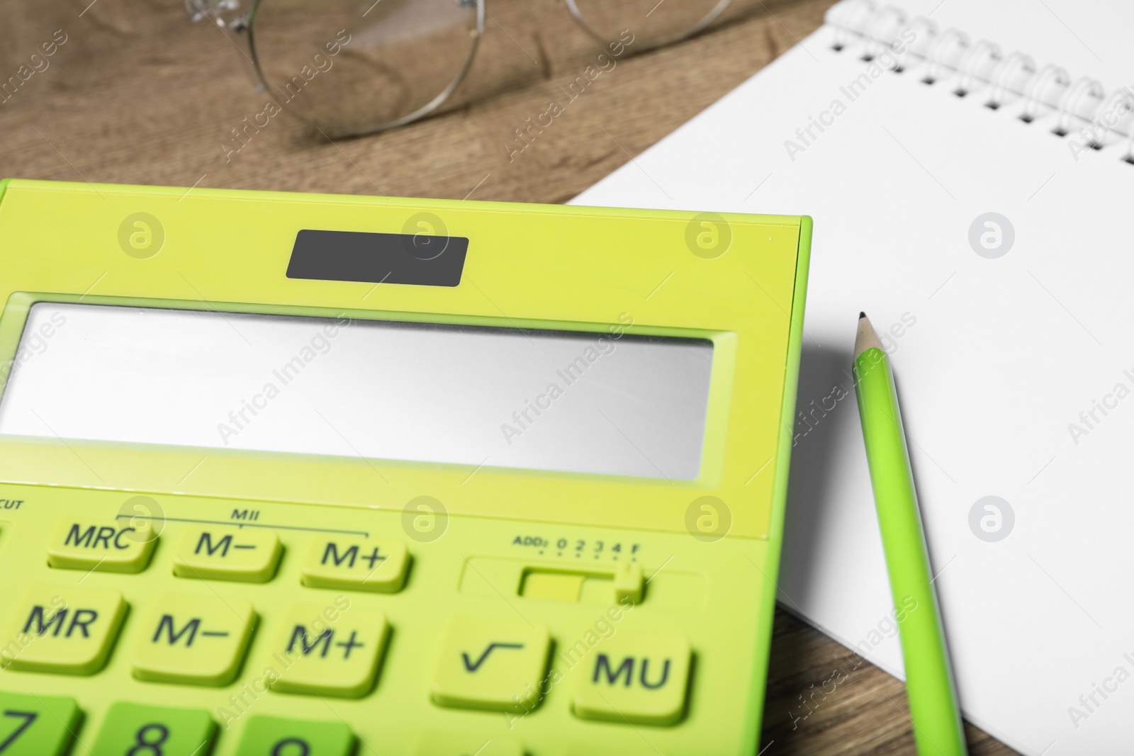 Photo of Calculator, notebook, pencil and glasses on wooden table, closeup. Tax accounting