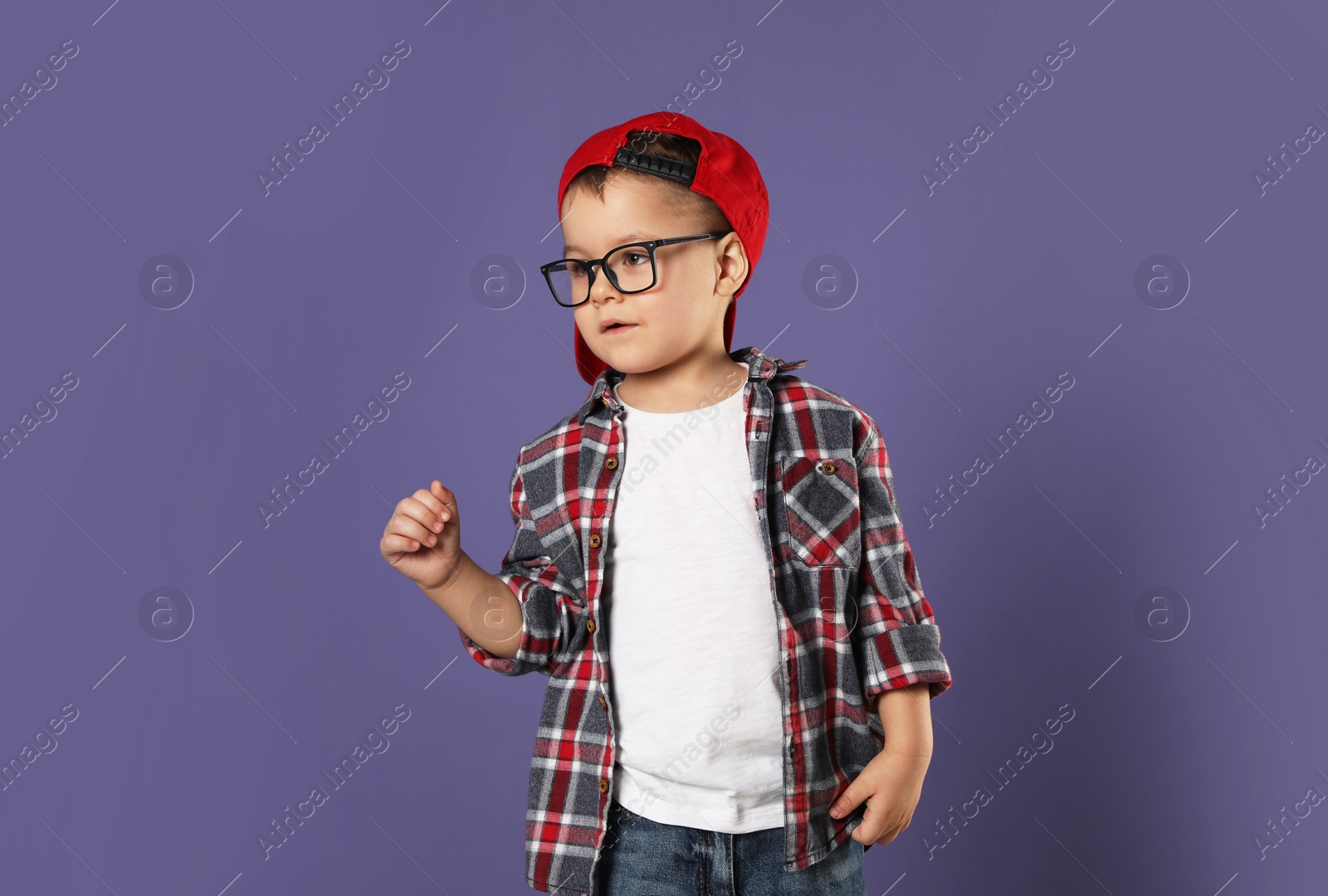 Photo of Cute little boy in glasses on purple background