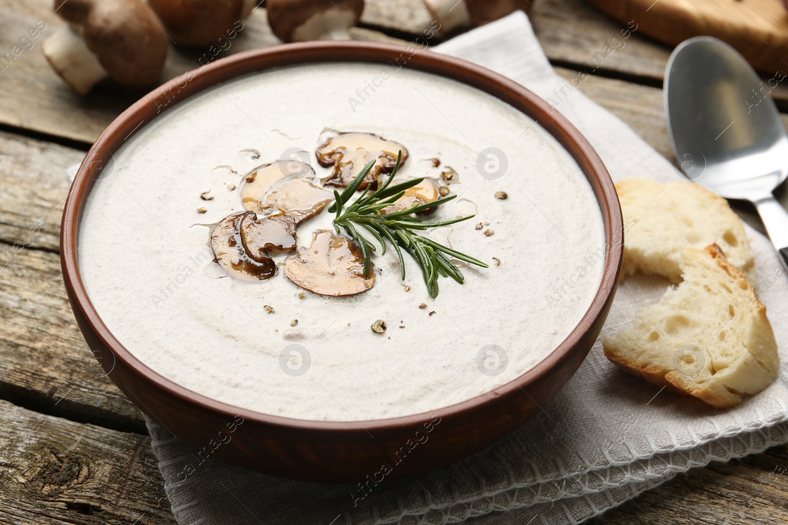 Photo of Fresh homemade mushroom soup served on wooden table, closeup