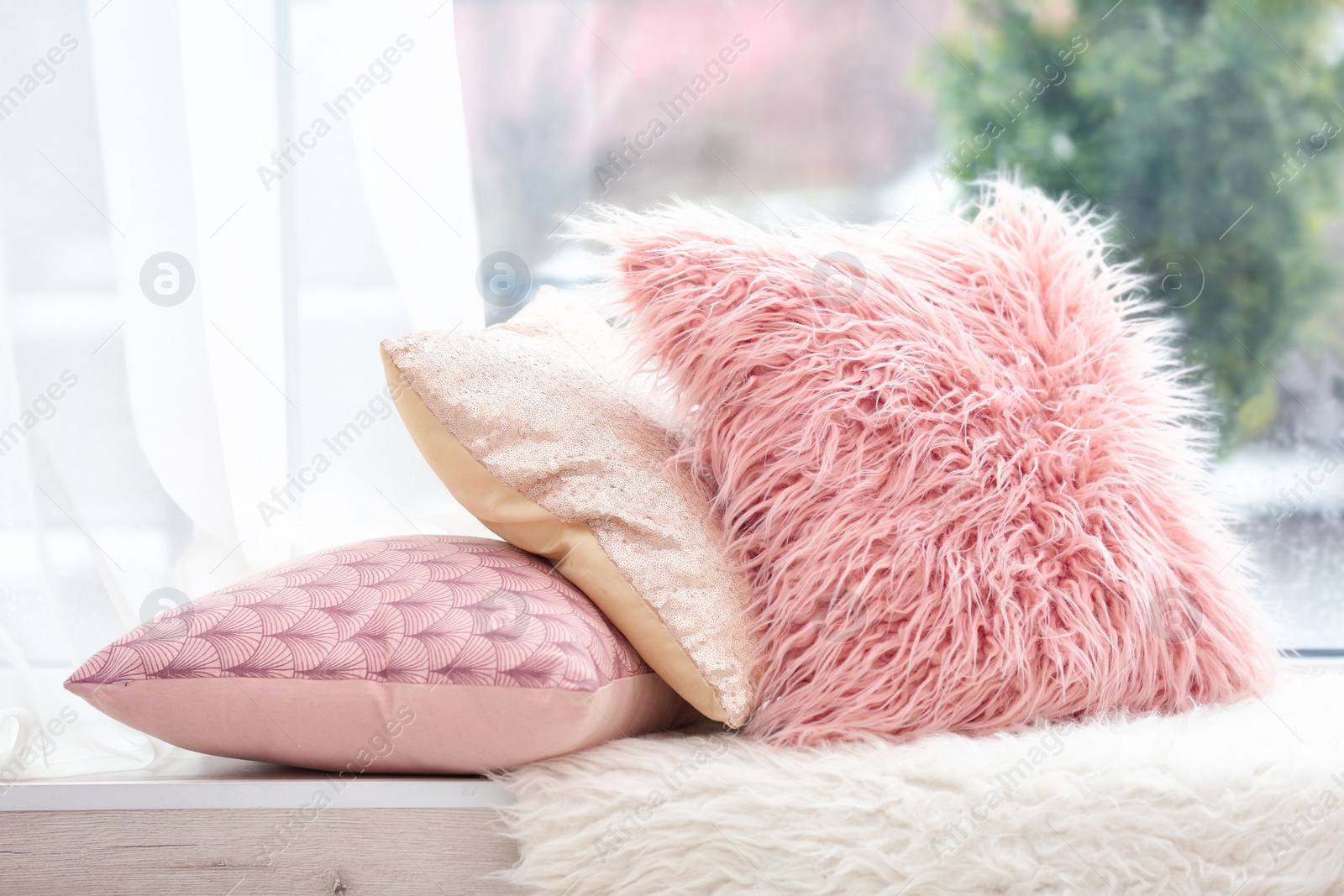 Photo of Different soft pillows on windowsill