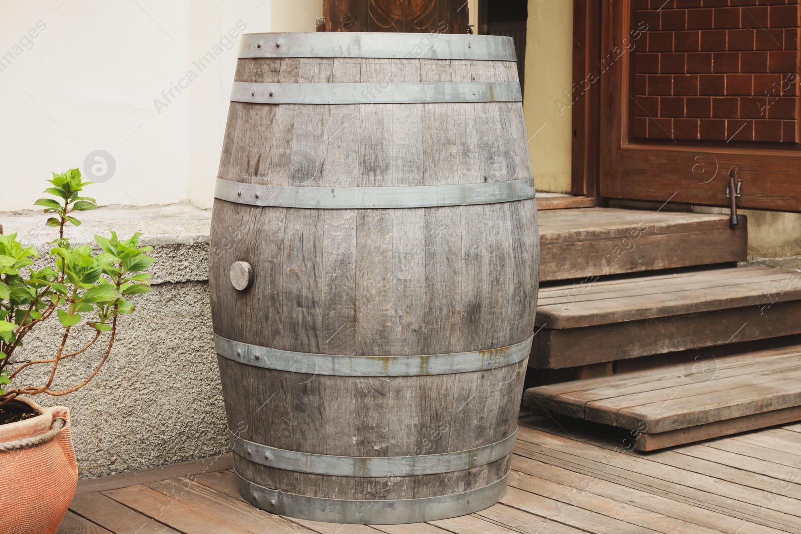 Photo of Traditional wooden barrel on street outdoors. Wine making