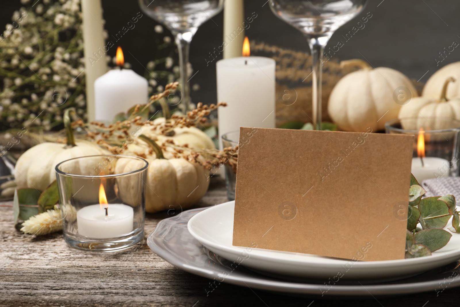 Photo of Beautiful autumn place setting with blank card and decor on wooden table, space for text