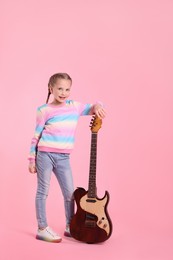 Photo of Cute girl with electric guitar on pink background