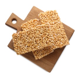 Photo of Wooden board with puffed rice bars (kozinaki) on white background, top view