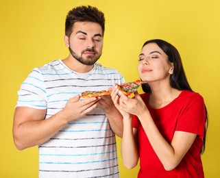 Photo of Emotional couple with pizza on yellow background