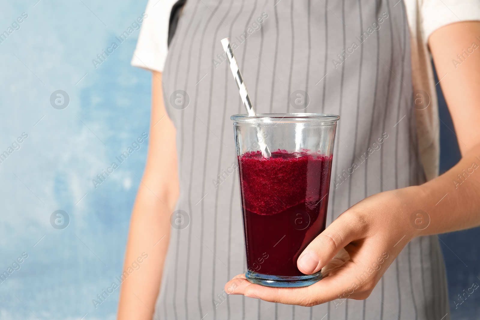 Photo of Woman with glass of beet smoothie on color background, closeup