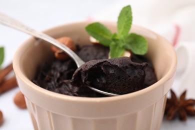 Tasty chocolate pie with mint on table, closeup. Microwave cake recipe