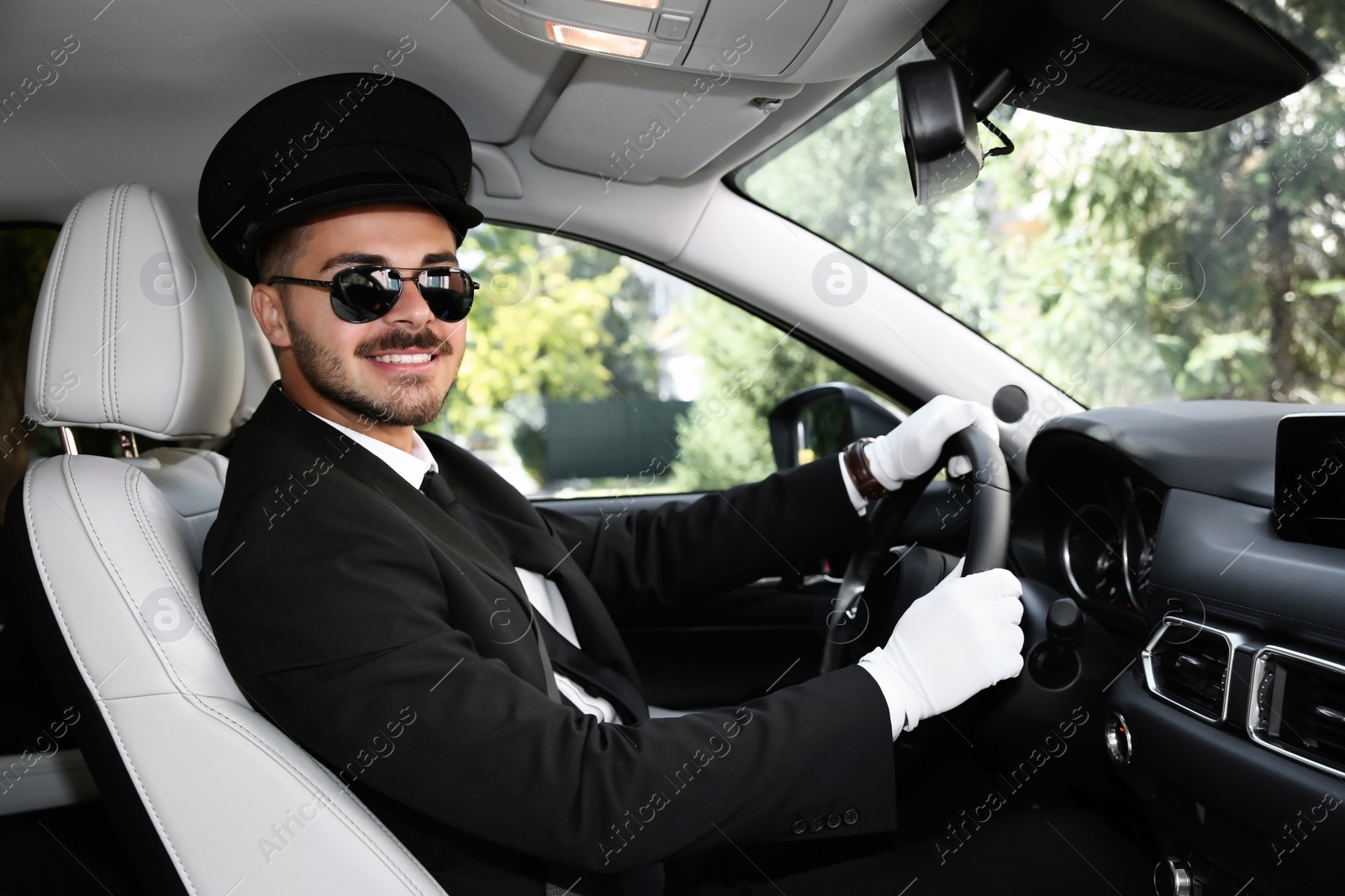 Photo of Young handsome driver in luxury car. Chauffeur service