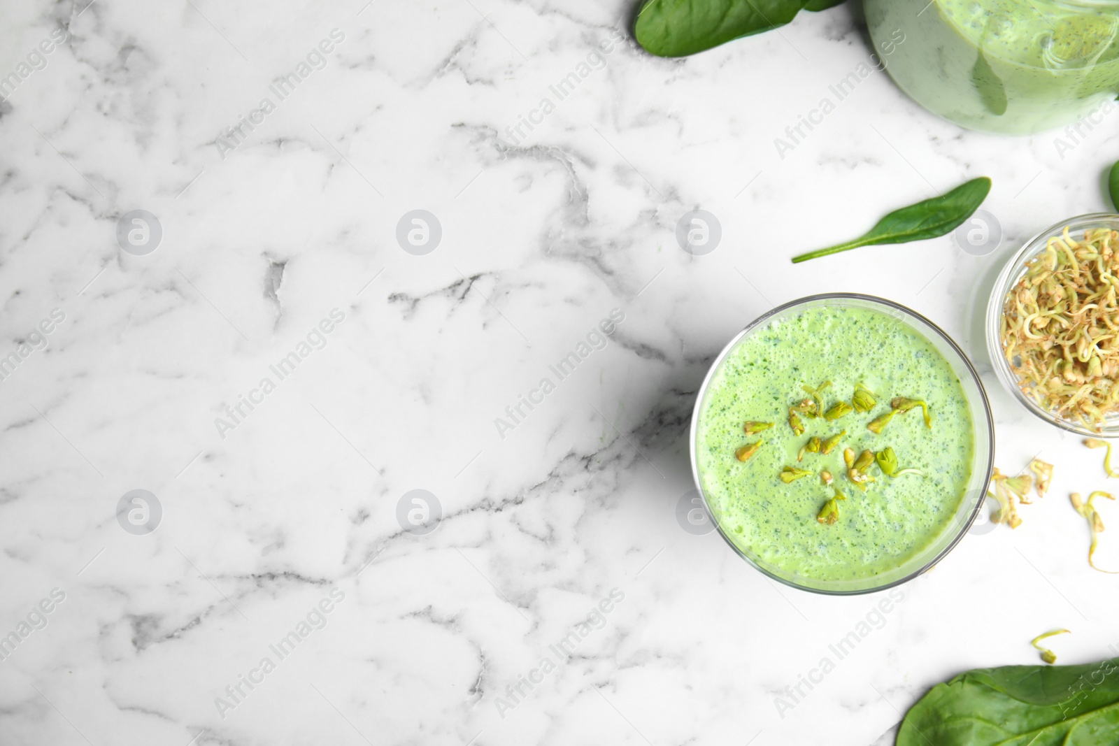 Photo of Flat lay composition with green buckwheat smoothie on white marble table, space for text