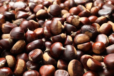 Photo of Fresh edible sweet chestnuts as background, closeup