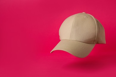 Photo of Baseball cap on pink background, space for text