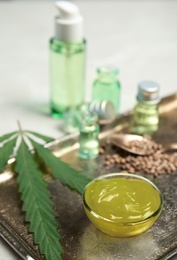 Photo of Bowl with hemp lotion on tray, closeup