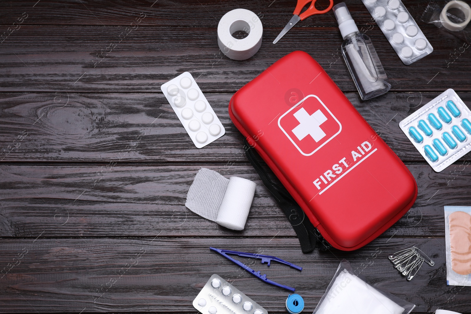 Photo of Flat lay composition with first aid kit on wooden table, space for text