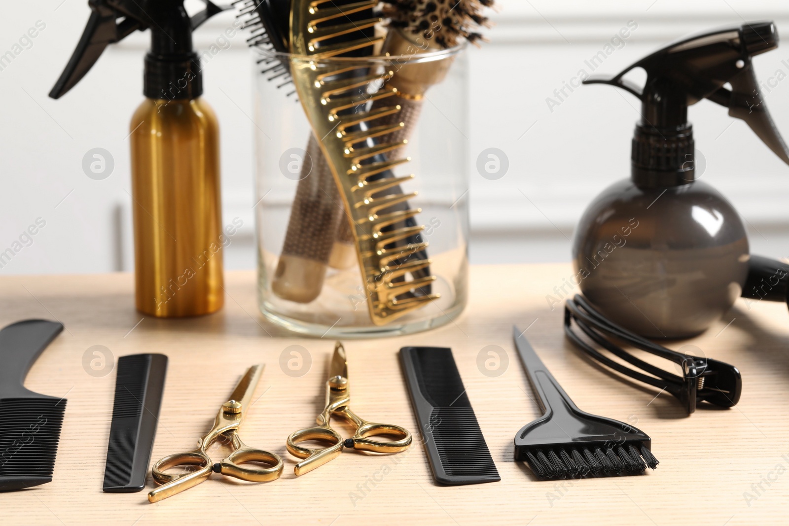 Photo of Hairdresser tools. Different scissors and combs on wooden table in salon