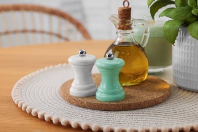 Photo of Salt and pepper shakers and bottle of oil on wooden table