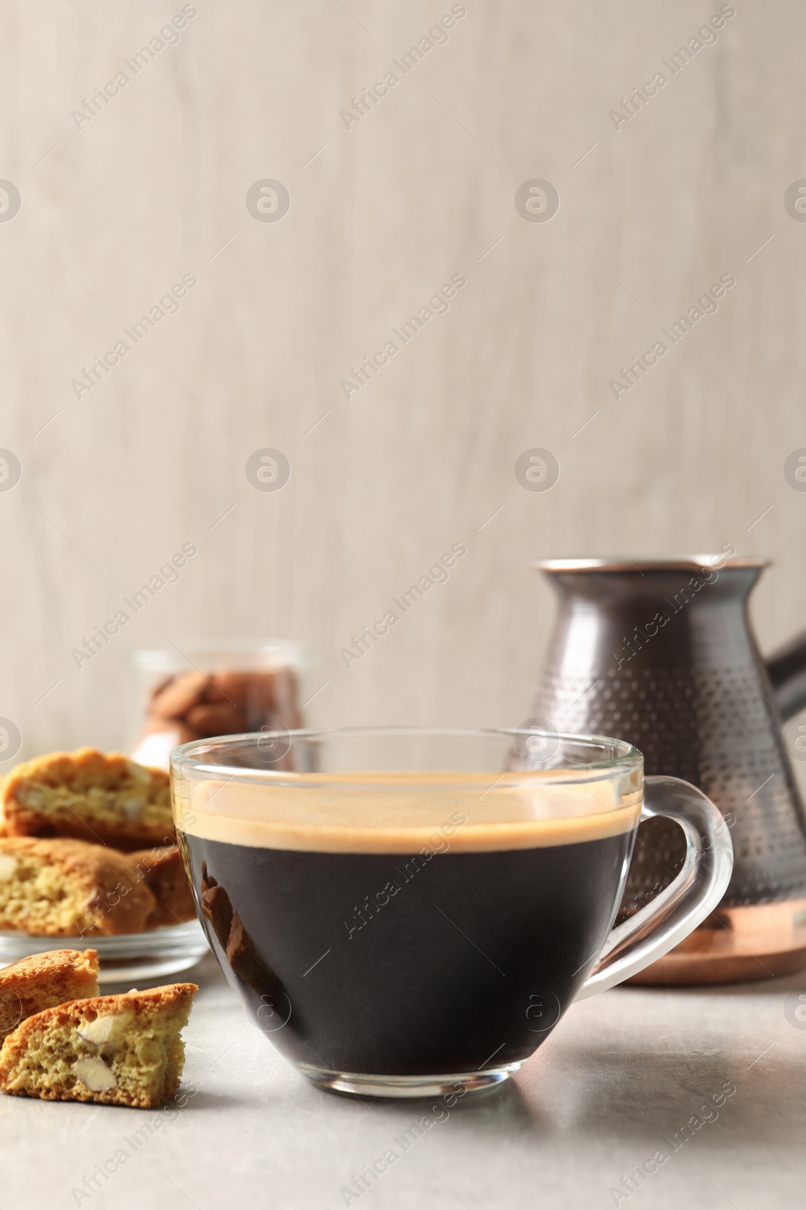 Photo of Tasty cantucci and cup of aromatic coffee on light grey table. Traditional Italian almond biscuits