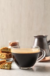 Tasty cantucci and cup of aromatic coffee on light grey table. Traditional Italian almond biscuits