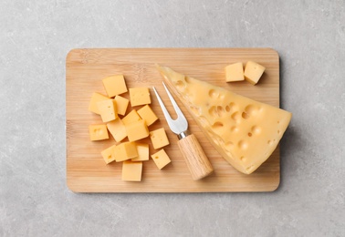 Tasty fresh cheese with fork on grey table, top view