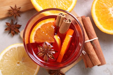 Photo of Aromatic punch drink and ingredients on light grey table, flat lay