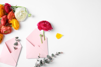 Photo of Composition with beautiful ranunculus flowers and envelopes on white background