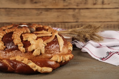 Fresh korovai on wooden table, space for text. Ukrainian bread and salt welcoming tradition