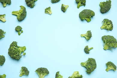 Photo of Fresh tasty broccoli on light blue background, flat lay. Space for text