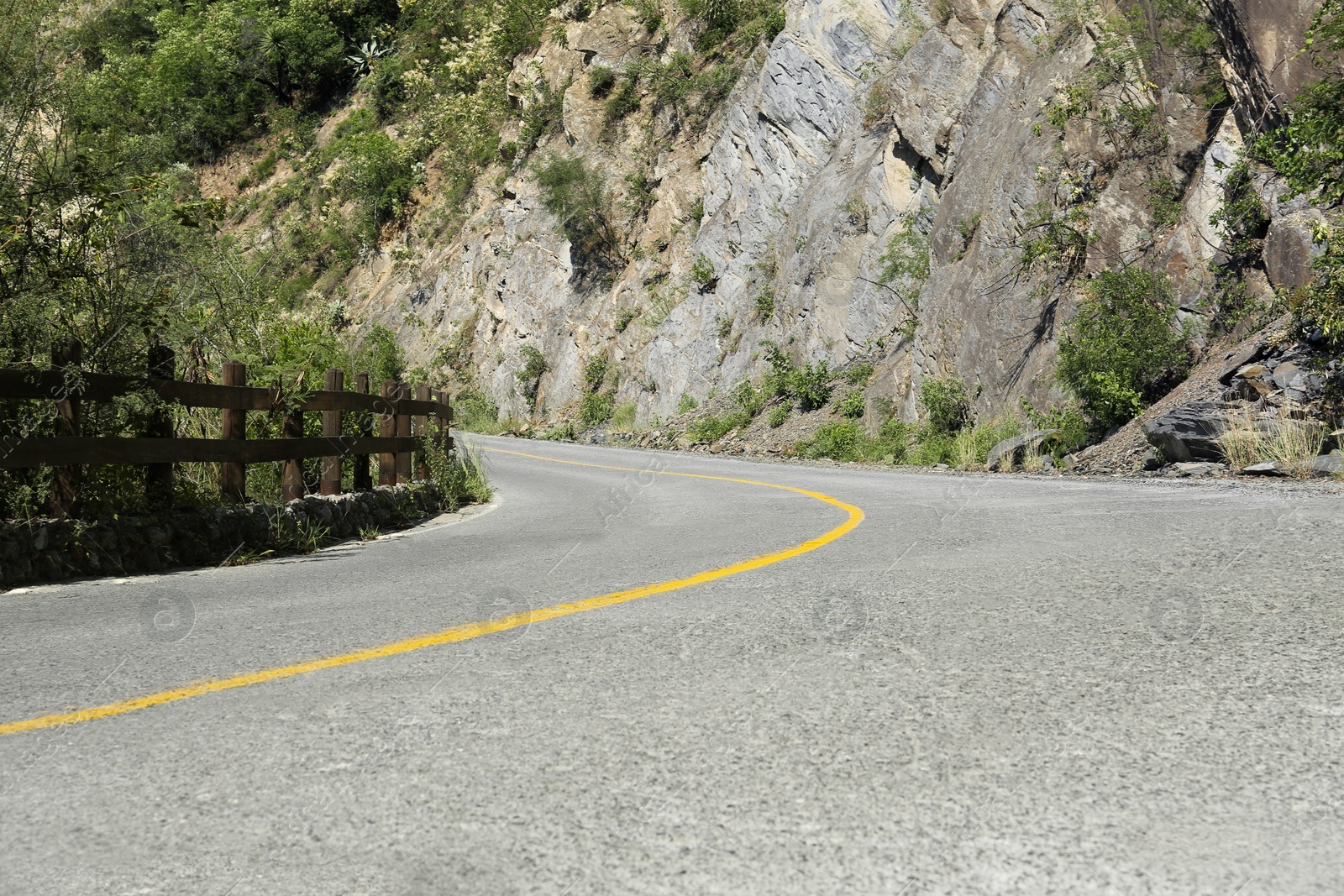 Photo of Asphalt road with yellow line near mountains outdoors