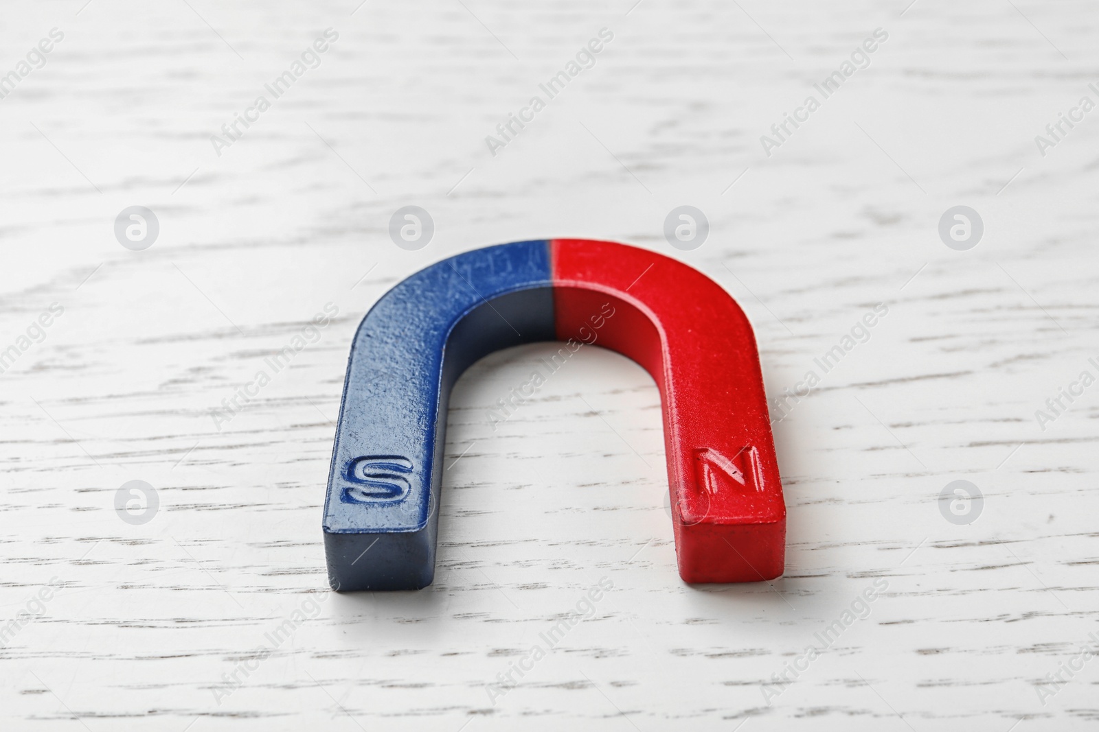 Photo of Red and blue horseshoe magnet on wooden background