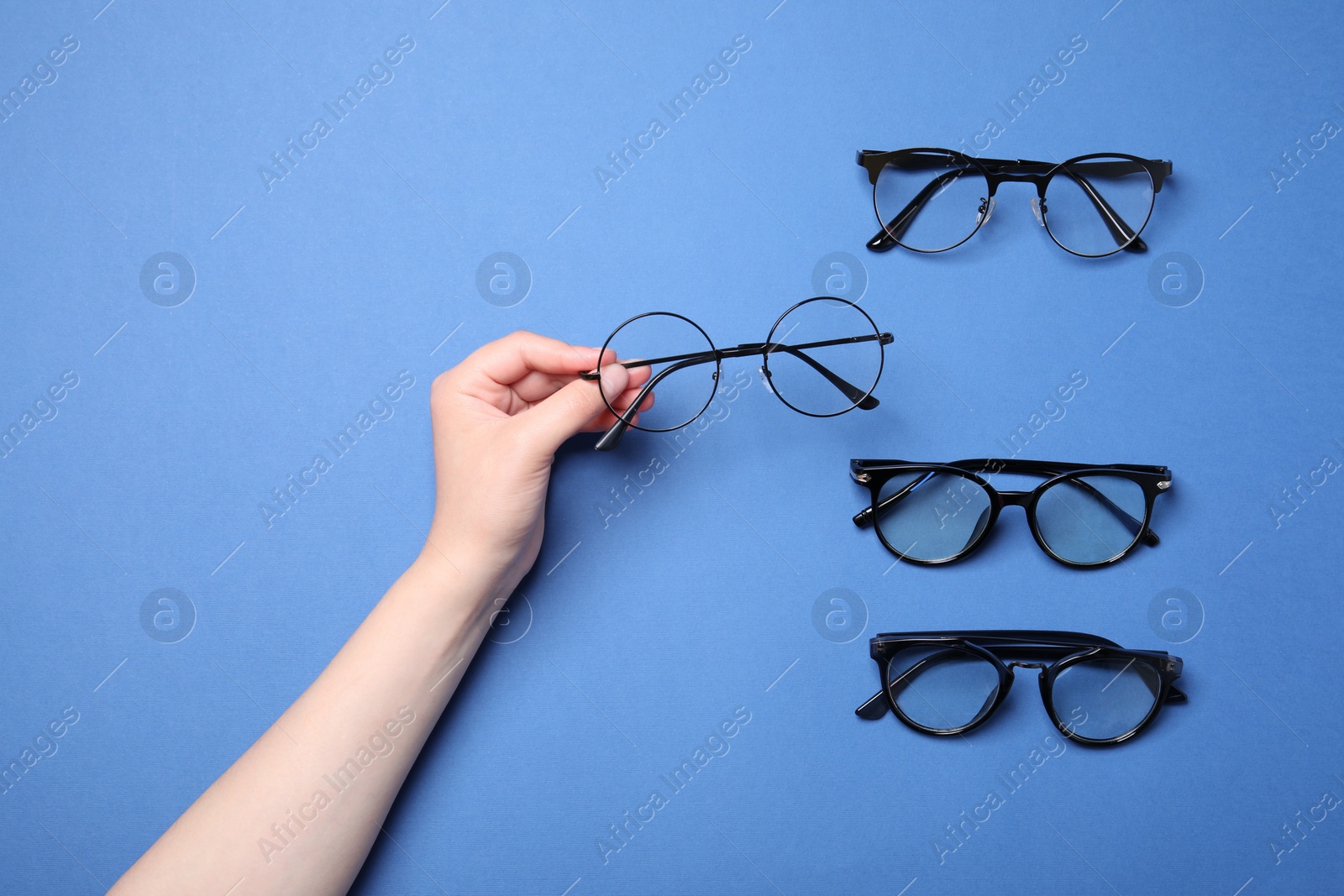 Photo of Woman with different stylish glasses on blue background, top view