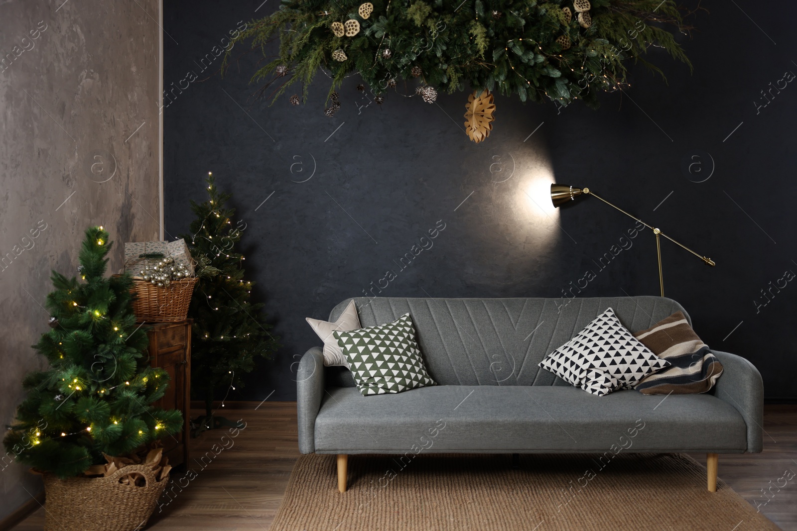 Photo of Stylish living room with comfortable sofa and Christmas trees. Interior design