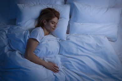 Photo of Woman sleeping in bed at night, above view. Space for text
