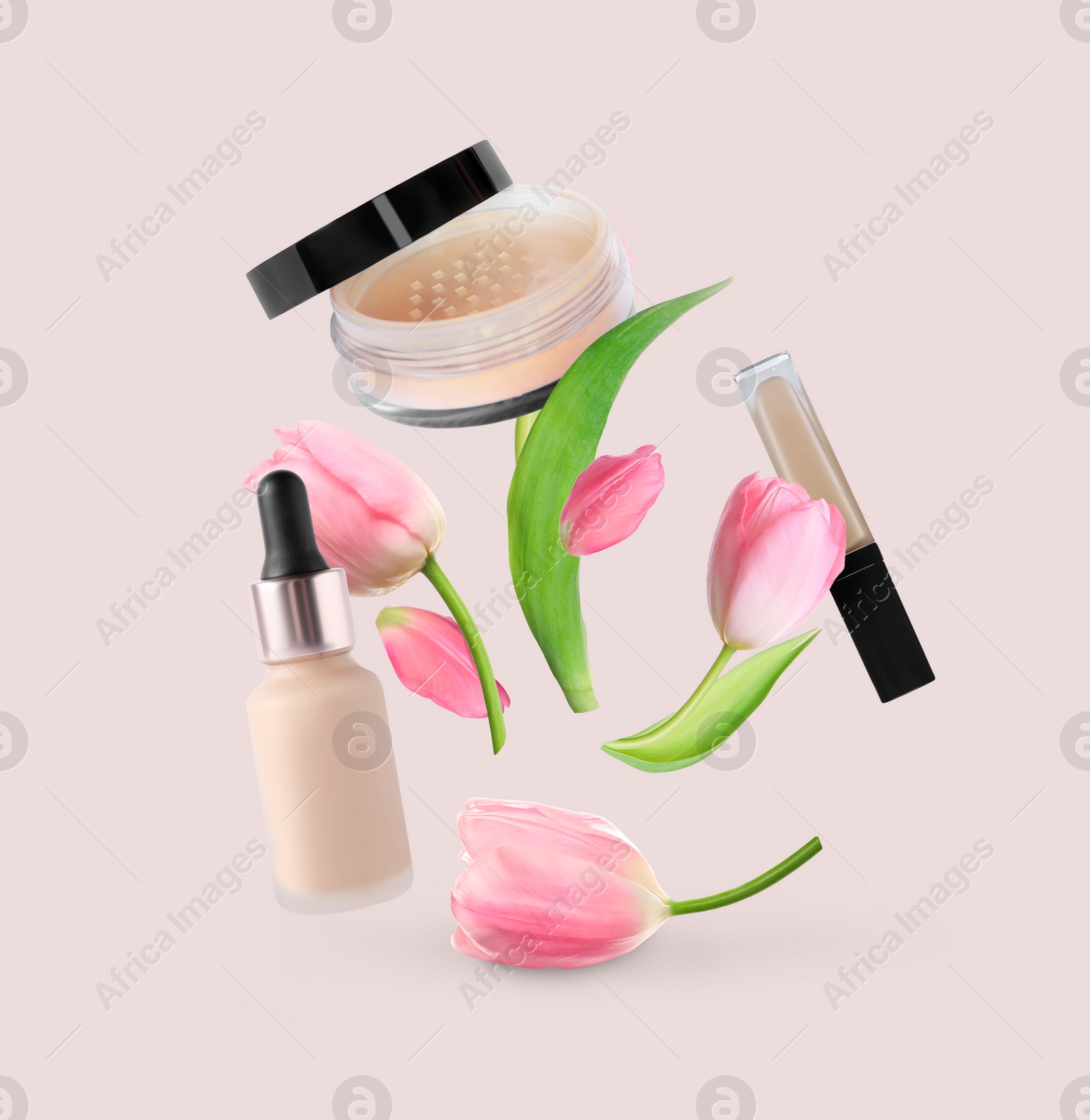 Image of Spring flowers and makeup products in air on beige background