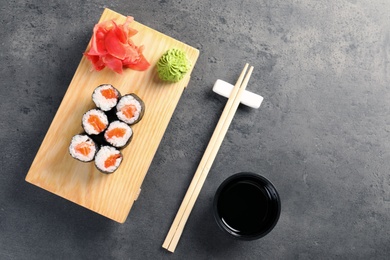 Tasty sushi rolls on served grey table, top view. Food delivery